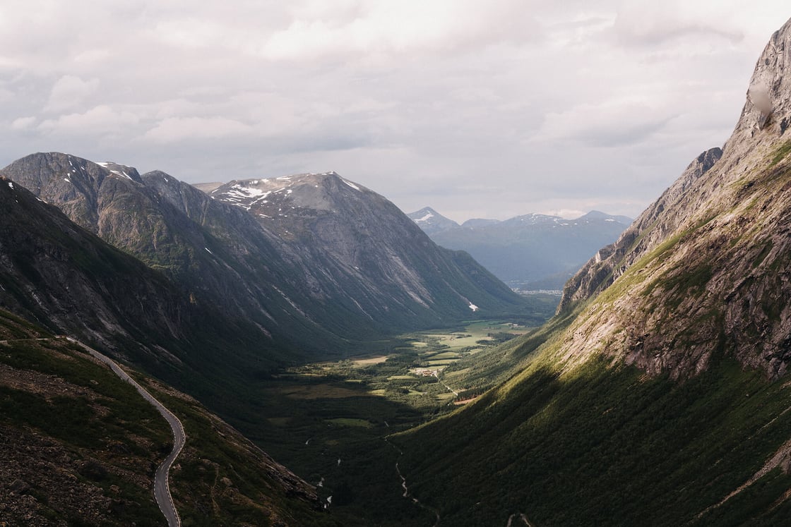 beautiful-wide-shot-mountains-facing-each-other-covered-with-green-grass