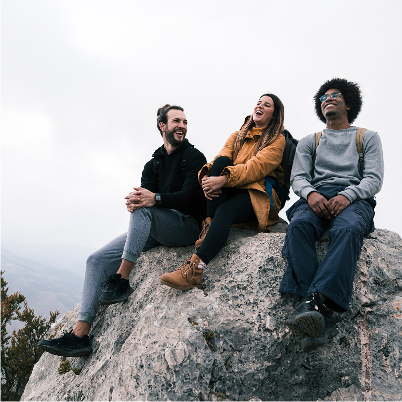 young-female-male-hiker-sitting-rock-enjoying 1